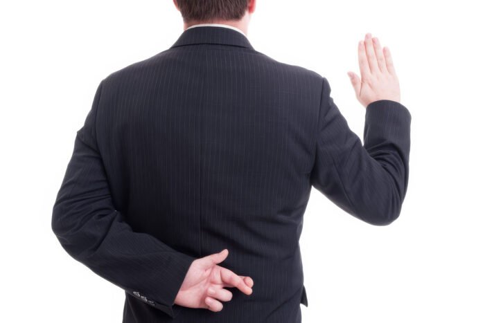 Business man swearing false with crossed fingers behing back