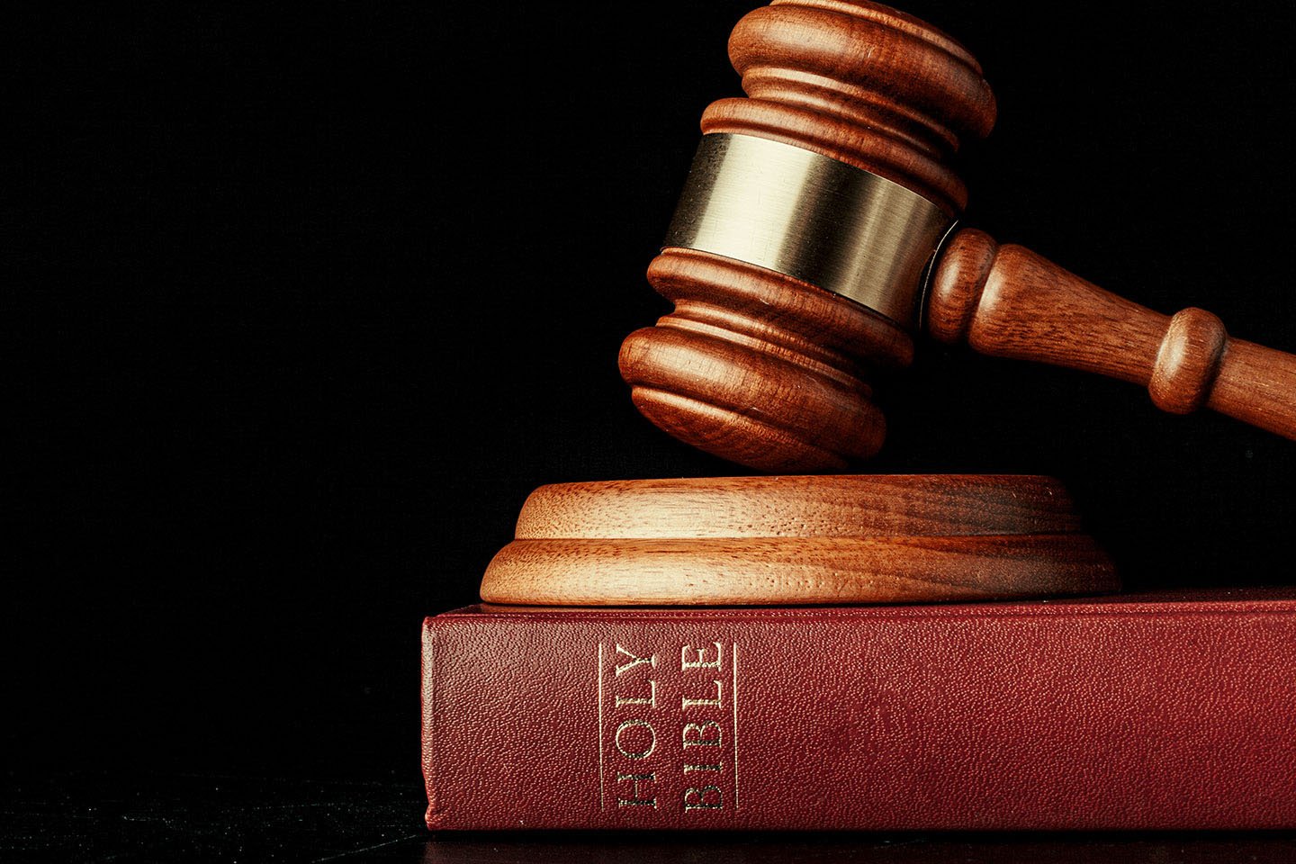 judge gavel with holy bible on black background